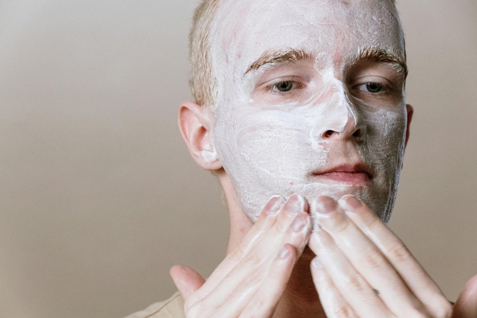 Close-up of a man applying facial cleanser for a refreshing skincare routine, focusing on self-care and health.